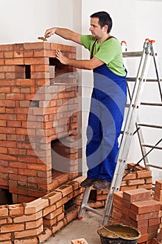 Worker building masonry heater