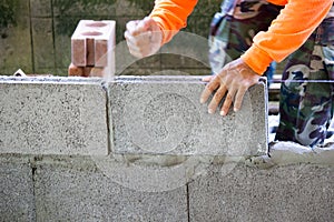 Worker building masonry house wall with bricks