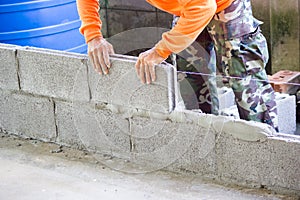 Worker building masonry house wall with bricks