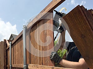A worker is building a nice fence