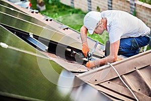 Worker building photovoltaic solar panel system, using ruler to measure mounting equipment.