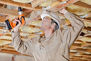 worker building roof frame on high