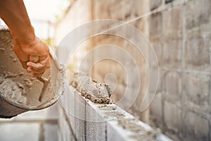 Worker building wall bricks with cement local Thailand