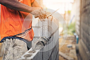 Worker building wall bricks with cement local Thailand