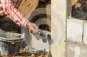 Worker building wall on sunny day