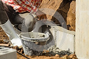 Worker building wall on sunny day