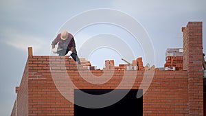 Worker builds wall of bricks. builder on building making bricklaying. builder at construction site makes brickwork