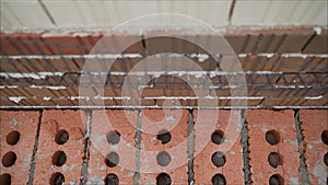 Worker builds a wall of colored brick. Worker in Close up of industrial bricklayer installing bricks and mortar cement brick on