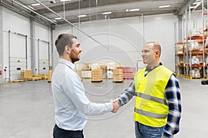 Worker and businessman with clipboard at warehouse