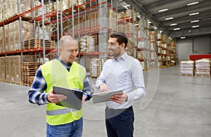 Worker and businessman with tablet pc at warehouse