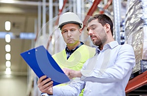 Worker and businessmen with clipboard at warehouse