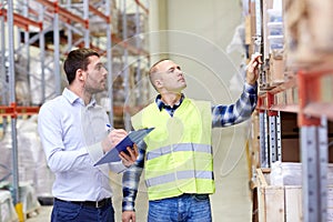 Worker and businessmen with clipboard at warehouse