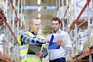 Worker and businessmen with clipboard at warehouse