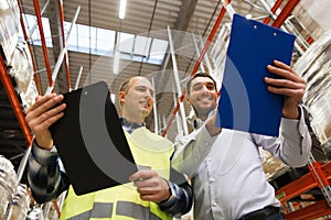 Worker and businessmen with clipboard at warehouse