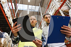 Worker and businessmen with clipboard at warehouse