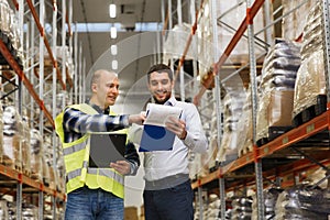 Worker and businessmen with clipboard at warehouse