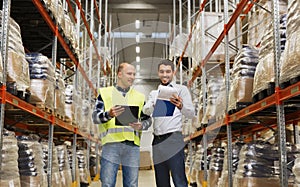 Worker and businessmen with clipboard at warehouse