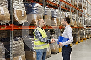 Worker and businessmen with clipboard at warehouse