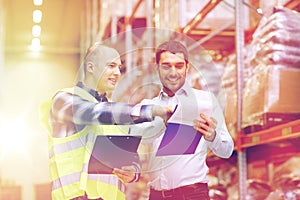 Worker and businessmen with clipboard at warehouse