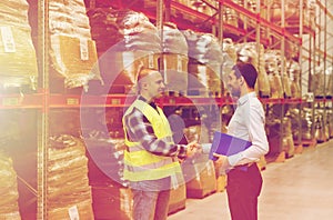 Worker and businessmen with clipboard at warehouse