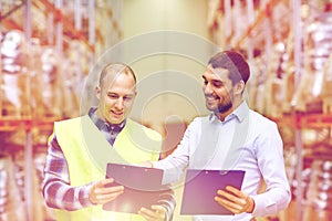 Worker and businessmen with clipboard at warehouse