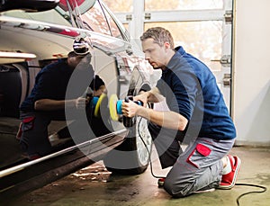 Obrero sobre el auto lavar 