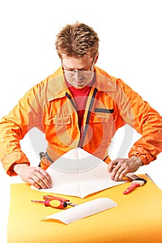 Worker carefully folds a paper