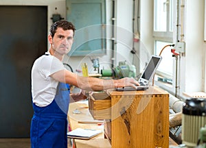 Worker in a carpenter's workshop with computer