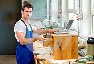 Worker in a carpenter's workshop with computer