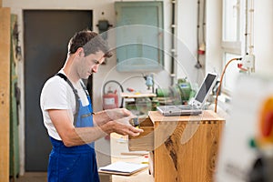 Worker in a carpenter's workshop with computer