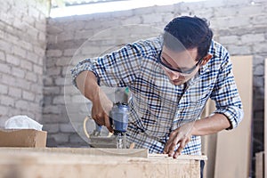 Worker at carpenter workspace installing nail using pneumatic na