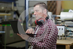 worker in carpenters workshop with computer