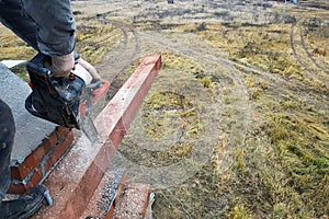 The worker carries out wood processing using chainsaws in the construction of the house