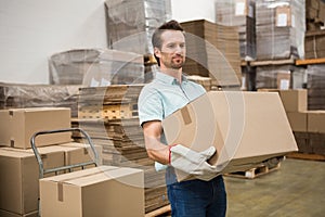 Worker carrying box in warehouse