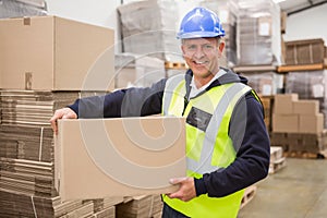 Worker carrying box in warehouse