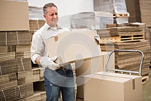 Worker carrying box in warehouse