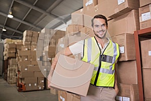 Worker carrying box in warehouse