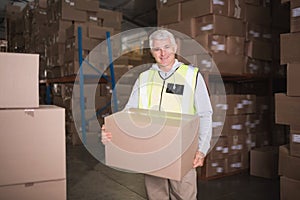 Worker carrying box in warehouse