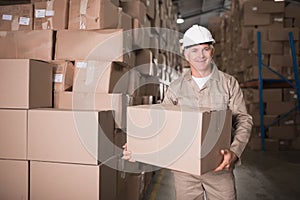 Worker carrying box in warehouse