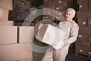 Worker carrying box in warehouse