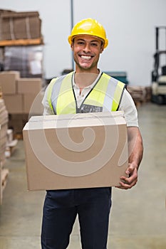 Worker carrying box in warehouse