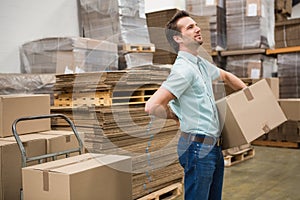 Worker carrying box in warehouse