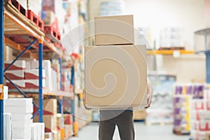 Worker carrying boxes in warehouse