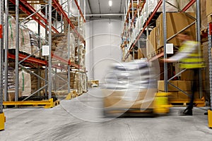 Worker carrying loader with goods at warehouse