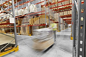 Worker carrying loader with goods at warehouse