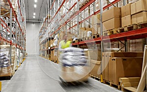 Worker carrying loader with goods at warehouse
