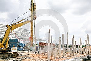 Worker carrying out ground piling work at construction site