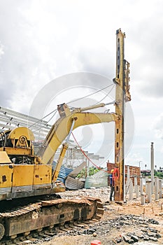 Worker carrying out ground piling work at construction site