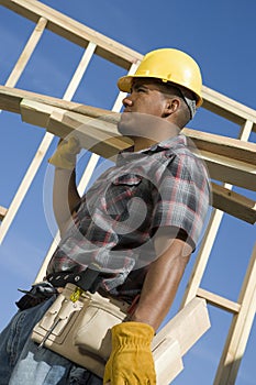 Worker Carrying Planks Of Wood