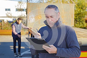 worker checking clipboard in shipping yard